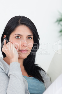 Woman phoning while resting on a couch
