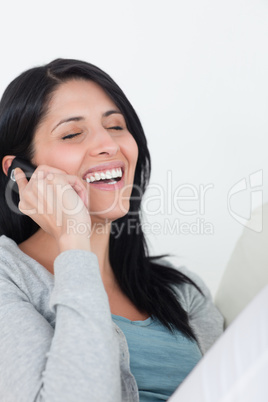 Woman laughing while phoning