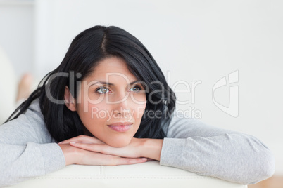 Woman crossing her arms under her head on a sofa