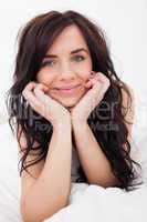 Brown-haired woman lying on her white blanket