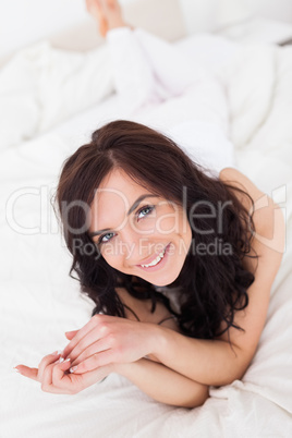 Happy brown-haired woman lying on her blanket