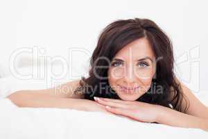 Calm brunette woman lying while smiling