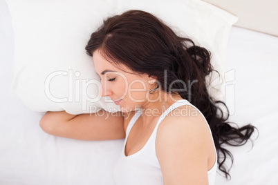 Brunette woman lying on the side while sleeping