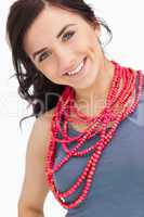 Blue eyed brunette posing with a red bead necklace