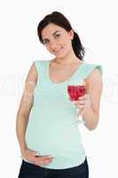 Young pregnant woman holding a mocktail