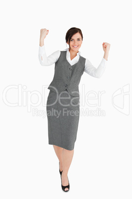 Woman in grey suit walking the fists raised