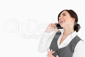 Brunette laughing while making a call with her smartphone