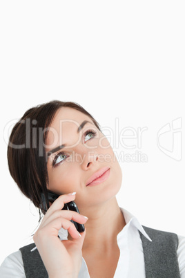 Brunette in suit looking up while phoning