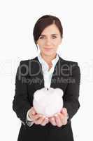 Beautiful businesswoman holding a piggy-bank