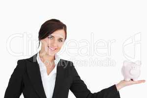 Smiling businesswoman with a piggy-bank on her palm