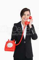 Businesswoman holding an old red phone