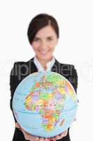 Brunette businesswoman holding an earth globe