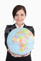 Brunette businesswoman holding an earth globe