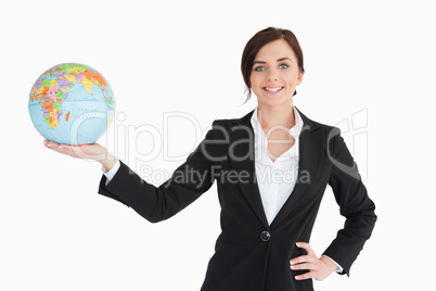 Smiling businesswoman holding an earth globe in her palm