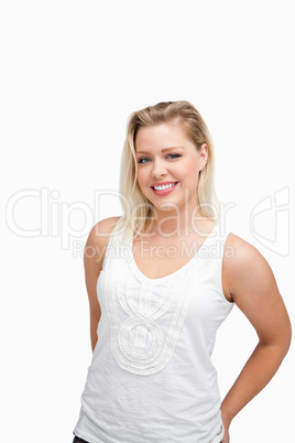 Relaxed blonde woman standing with her hands behind her back