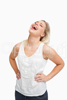 Blonde woman laughing while placing her hands on her hips