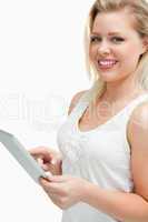 Cheerful blonde woman touching her tablet computer