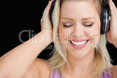 Smiling blonde woman wearing her headphones