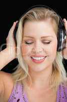 Joyful blonde woman wearing her headphones