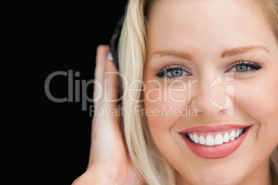 Blonde woman closing her eyes while listening to music