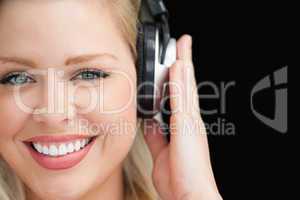 Smiling blonde woman listening to music through headphones