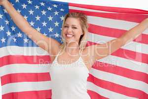 Joyful blonde woman holding the Stars and Stripes flag
