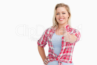 Happy blonde woman placing her thumbs up