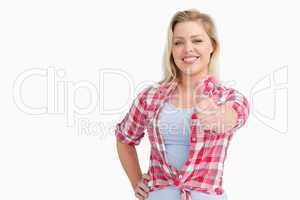 Happy blonde woman placing her thumbs up