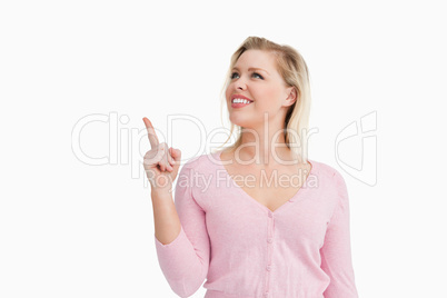 Smiling woman pointing at a blank space