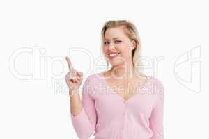 Joyful attractive woman pointing her finger up