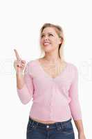 Blonde woman pointing her finger up while looking up