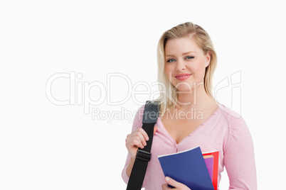 Peaceful blonde woman holding notebooks