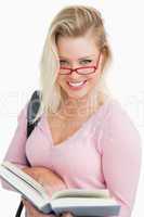 Happy blonde woman looking over her red glasses