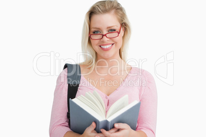 Happy woman holding a book while standing