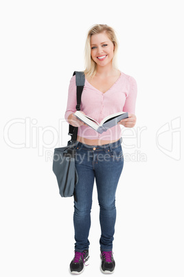 Happy woman standing while holding a novel Happy woman standing while holding a novel