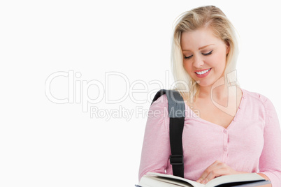 Smiling blonde woman reading an interesting novel