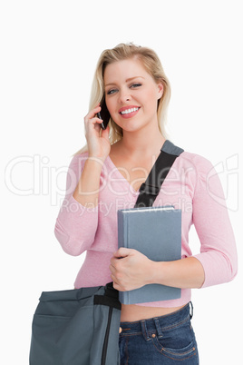 Happy woman standing while using her cellphone