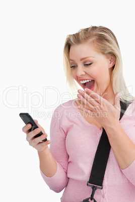 Surprised blonde woman looking at her mobile phone Surprised blonde woman looking at her mobile phone