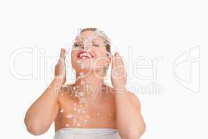 Blonde woman splashing her face