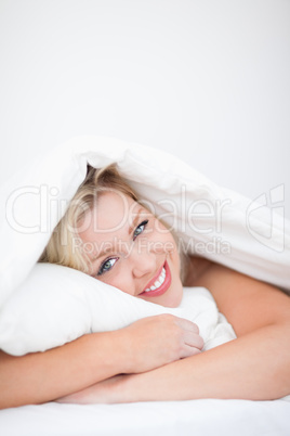 Young smiling woman embracing a pillow