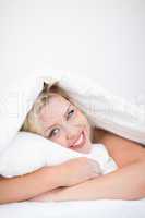 Young smiling woman embracing a pillow