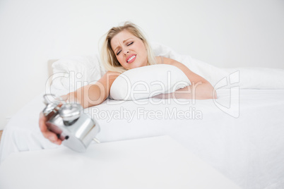 Upset woman looking at her alarm clock