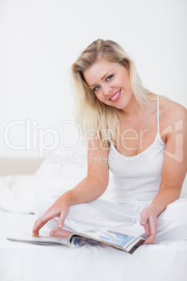 Blonde smiling with a magazine
