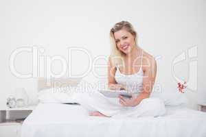 Blonde using an ebook reader while sitting