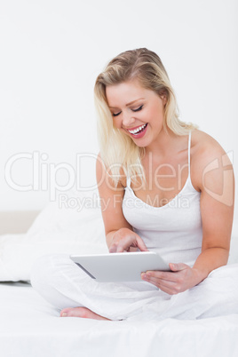 Blonde laughing while using an ebook