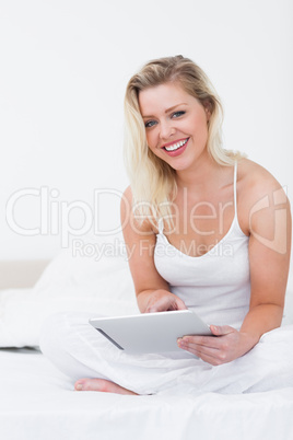 Blonde smiling while holding an ebook