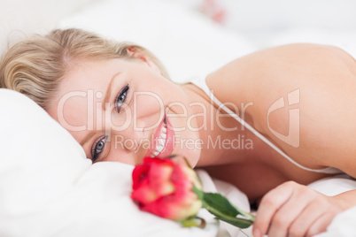 Blue eyed woman smiling with a rose