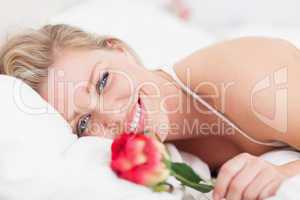 Blue eyed woman smiling with a rose