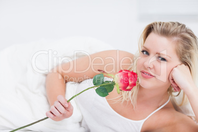 Young woman holding a pink rose