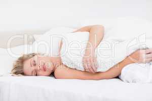 Young woman sleeping under a white duvet